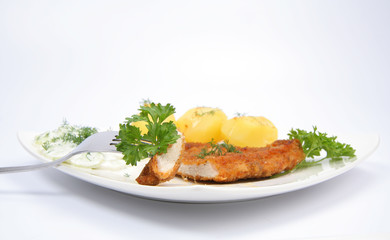 Pork chop with potatoes, cucumber salad and parsley