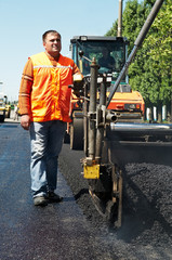 Young paver worker at asphalting works