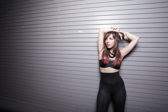 Punk glam rocker female posing on a metal background