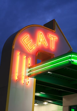 Twilight photo of a neon eat sign