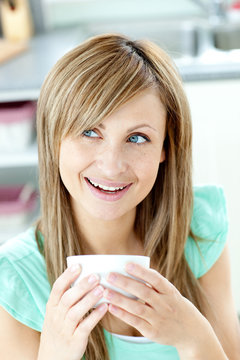 Portrait of a woman holding a cup of tea in the kitchen
