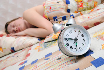 Alarm clock about sleeping the girl