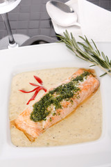 Cooked salmon fillets with  sauce on white plate