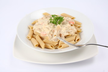 Penne with white sauce on with parsley some of it on a fork