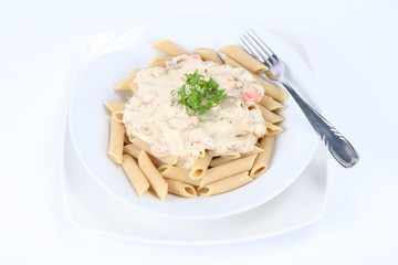 Penne with white sauce on a plate decorated with parsley
