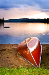 Lake sunset with canoe on beach