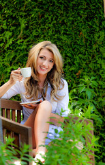 Frau trinkt Kaffee zum Frühstück im Garten. Relaxen