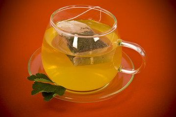 Transparent tea cup on red background