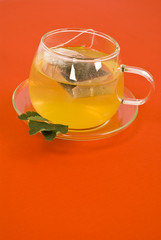 Transparent tea cup on red background