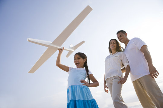 Hispanic Family And Girl Having Fun With Toy Plane