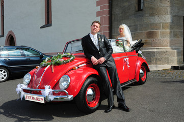 bridal couple with wedding car
