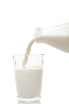 Milk being poured in a glass isolated on a white background