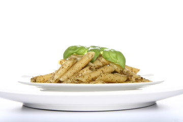 Penne with pesto decorated with basil on a plate