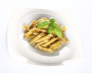 Penne with pesto decorated with basil on a plate