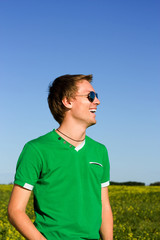 Naklejka premium Young man laughs in sunglasses