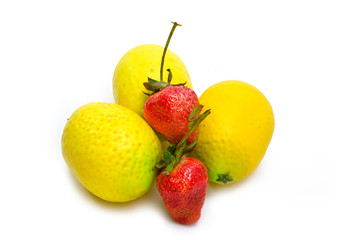 three lemons and two berries of strawberry on white background