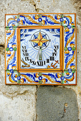 Ceramic sundial fixed upon a weathered wall near the city of Vil