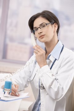 Young physician talking on phone