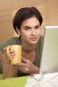 Portrait of woman having coffee in bed