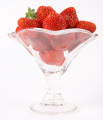 Strawberries in a cup decorated with a lemon balm twig on white