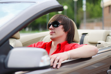 Young businessman sitting in a car.