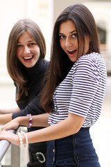 Closeup portrait of two happy pretty teenagers embracing