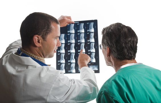 Two Doctors Examining Patient's Spinal Film Scans