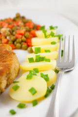 Close-up of potatoes with chive,schnitzel,peas and carrot