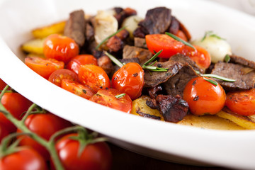 Beef with roasted cherry tomatoes,potatoes and onion