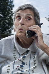 Elderly Senior Woman Talking on Phone With Surprised Expression