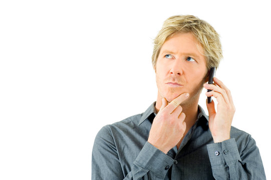 junger Mann mit kritischem Blick am Telefon