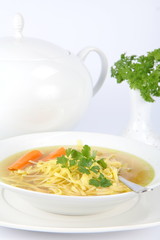 Chicken soup  with parsley and a soup tureen