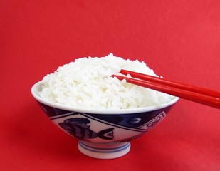 Bowl of white ricewith red chopsticks