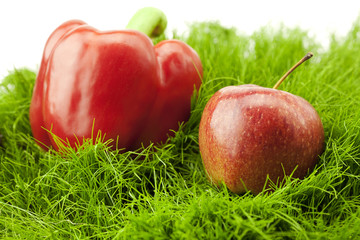 pepper and apple lying on green grass
