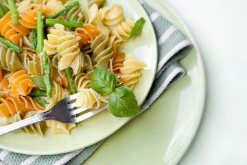 Colorful pasta with asparagus and rocket pesto and basil