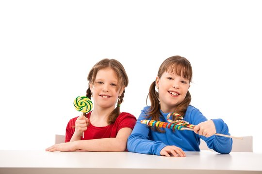 Smiling girls with lollipops