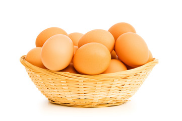 Brown eggs in the basket on white