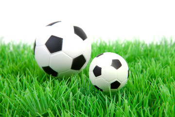 Fototapeta premium Two soccer balls on grass over white background
