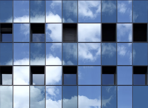 Spiegelung des Himmels in einer blauen Fensterfassade.