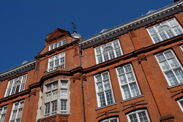 Fototapeta na wymiar Rote Hausfassade und weisse Sprossenfenster