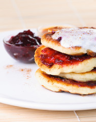 Fritters of cottage cheese with jam and sour cream