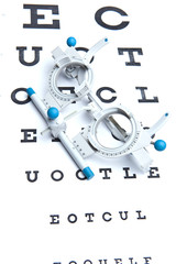 optometry concept - sight measuring spectacles & eye chart