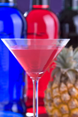 Cocktail im Cocktailglas vor einer Ananas