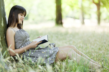 Naklejka na ściany i meble teen girl reading in nature