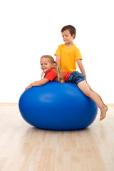 Fototapeta na wymiar Kids doing exercises on large rubber ball