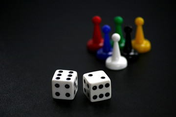 Dice and game pieces on black