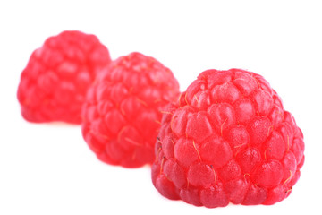 Three fresh  raspberries on white