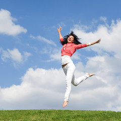 Fototapeta na wymiar pretty young woman jumping on green grass