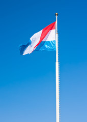 Flag of Luxembourg over blue sky