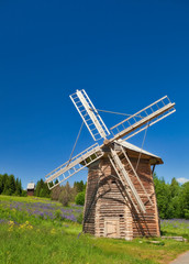 Fototapeta na wymiar Wooden windmill under clear sky